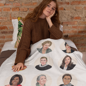a woman sitting on a bed covered in a blanket