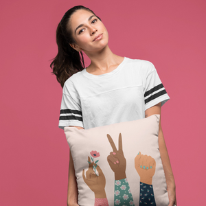 a woman holding a pillow with a peace sign on it